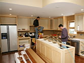 Two men work on renovation a home kitchen