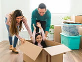 A young couple pushes their happy daughter in a box