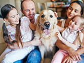 A happy family sits with their equally happy dog