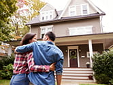 A couple walks to the front door of their home