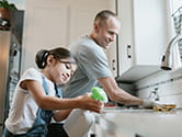 A father and daughter clean their home's kitchen together