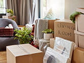 A number of packed boxes sits on the floor of a home living room