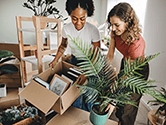 Two women unpack boxes in their new home