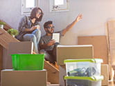 A young couple takes inventory of their moving boxes