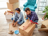 A younger couple packs boxes in their home