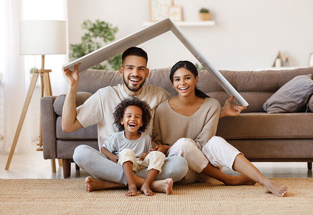 A happy family sits together in their home