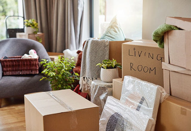 A number of packed boxes sits on the floor of a home living room