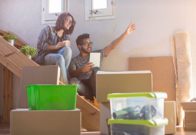 A young couple takes inventory of their moving boxes