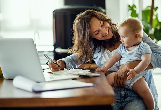 A mother plays with her baby while she gets work done