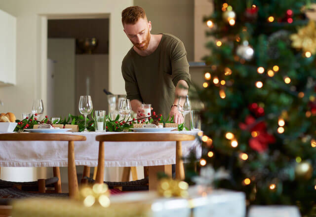 A man cleans and sets up the table for a holiday meal