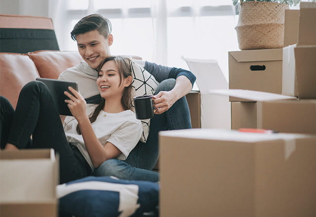 A happy couple sits in their new home