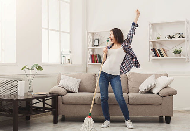 A woman sings in her home's clean living room