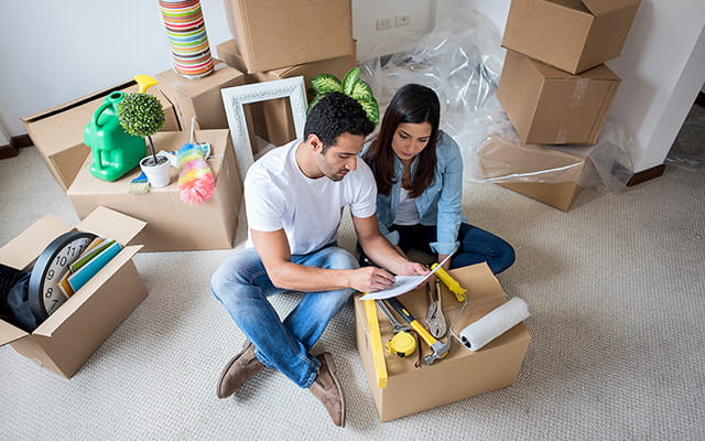 A couple discusses their move sitting around some boxes in their home