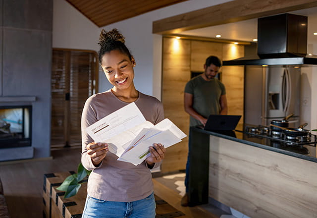 A woman checks her mail in her home