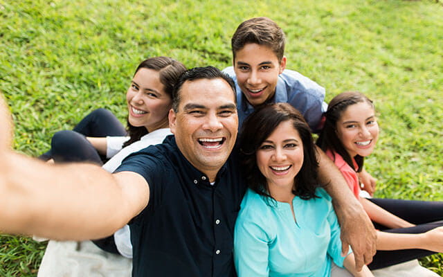 A happy family takes a selfie in their yard