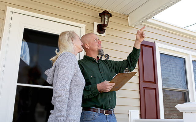 A homeowner speaks with a home inspector doing a report on her home