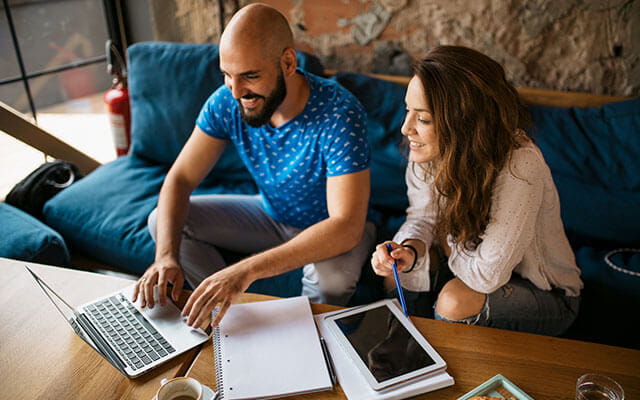 A happy couple checks their computer for help