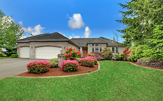 Exterior shot of a well manicured front yard of an upper middle class home