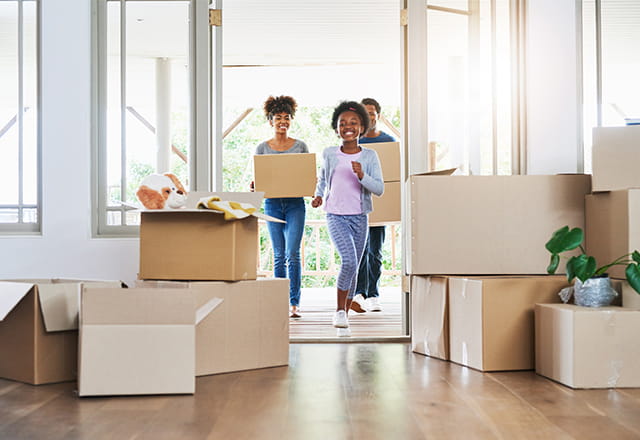 A family moves boxes into their new home