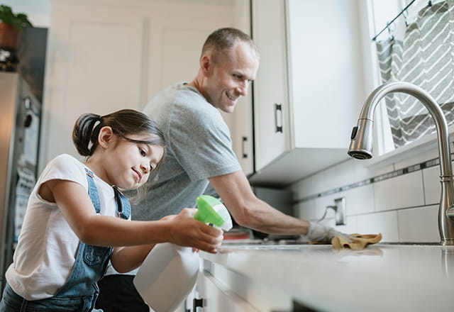 A father and daughter clean their home's kitchen together