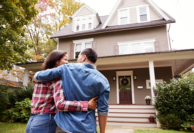 A couple walks to the front door of their home