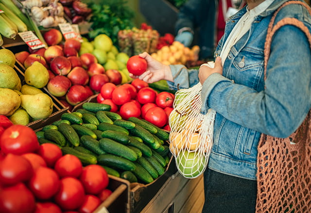 A woman picks produce at a store