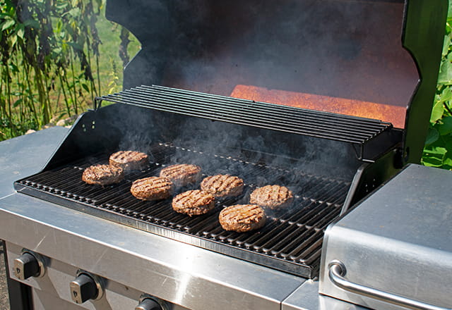 A grill with burgers getting cooked