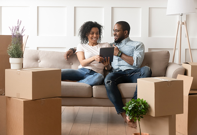 A couple smiles while viewing content on a tablet