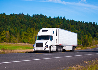 A refrigerated truck and trailer travel down the highway