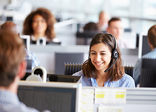 A smiling woman in a call center assists customers