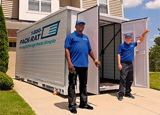 Movers stand in front of an open 1-800-PACK-RAT portable storage container