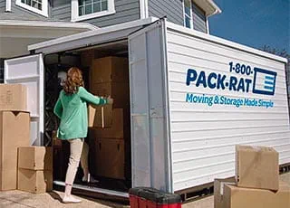 A customer loads boxes into her 1-800-PACK-RAT portable storage container