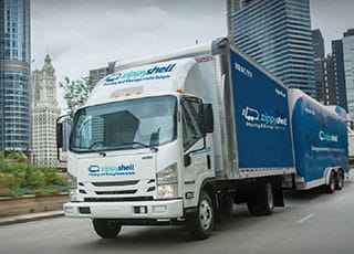 A Zippy Shell box truck and shell container on a city road