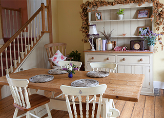 A rustic dining room table and chairs sit in a nice home