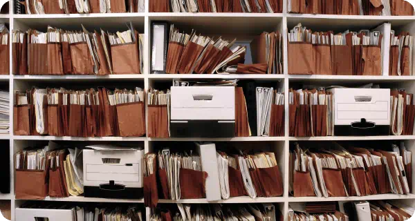 A view of a large number of files and office boxes with more files in them in an office environment