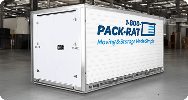 An empty 1-800-PACK-RAT container sits inside of a warehouse facility