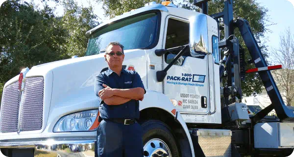 A 1-800-PACK-RAT driver standing in front of a truck