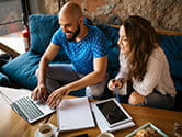 A happy couple checks their computer for help