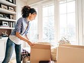 A woman packs boxes in her home