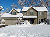 A residential home is covered in snow in the winter time