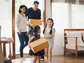 A family carries boxes in their home