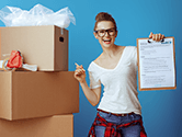 A woman holds a 1-800-PACK-RAT moving checklist in her hand next to some packed boxes