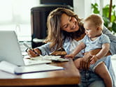 A mother plays with her baby while she gets work done