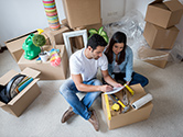 A couple discusses their move sitting around some boxes in their home