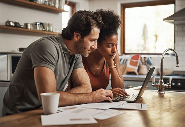 A couple looks at a laptop while making important decisions