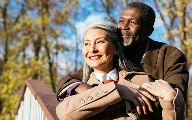 A happy retired couple looks on in the sunshine