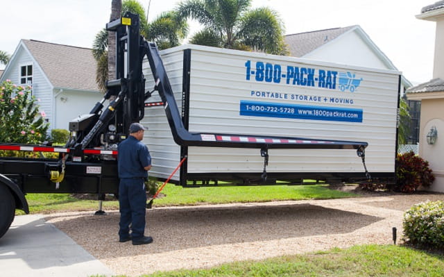 1-800-PACK-RAT container being lifted by truck.