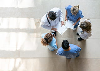 A group of medical professions huddle to discuss