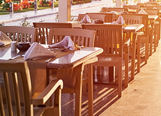 A series of tables and chairs in a restaurant's outdoor seating area