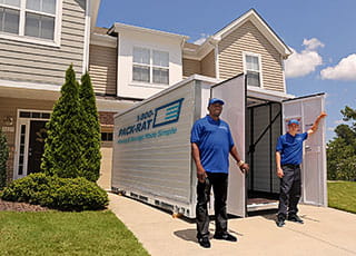 Workers stand in front of an open 1-800-PACK-RAT portable storage container